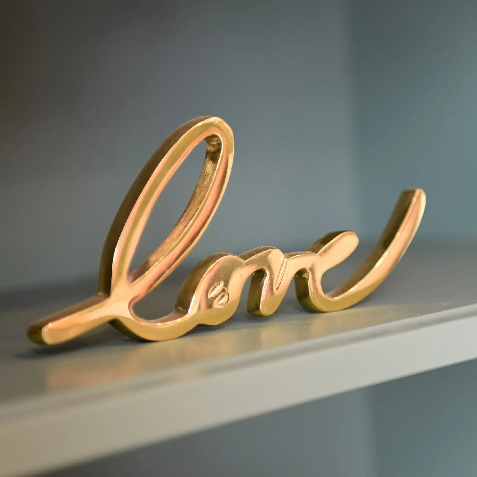 Gold script sign reading love on a shelf